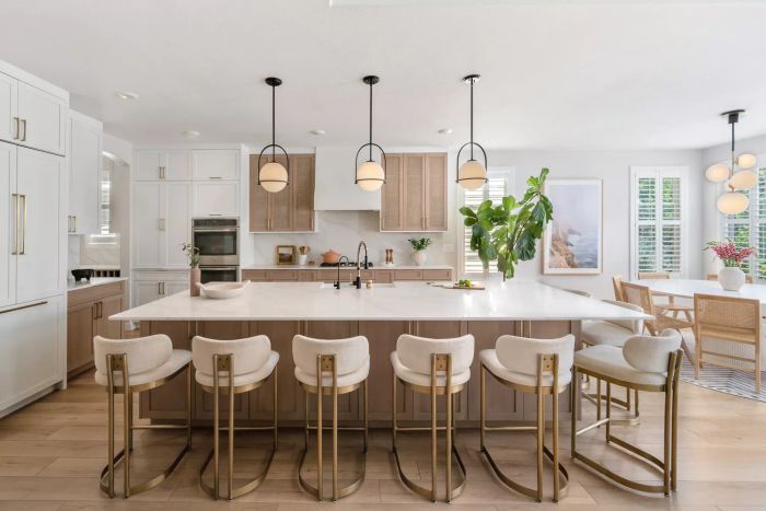 a luminous kitchen with woven mesh cabinet doors and a large central island accompanied by barstools
