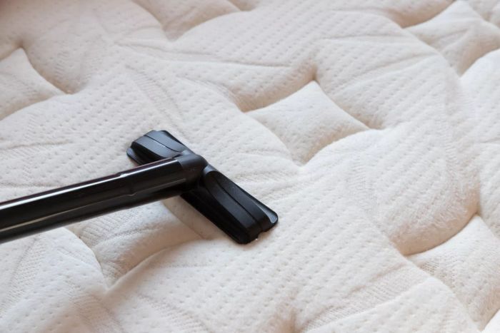 Vacuuming a Mattress. Dust mites on bedding, textures. Concept: Allergy issues in the bedroom.
