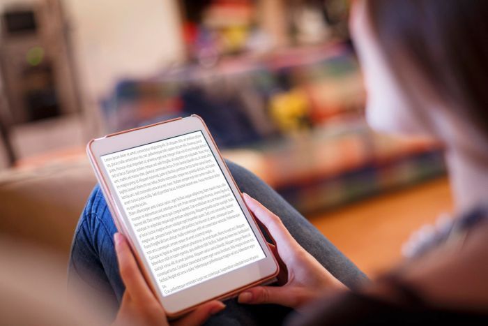 A person reading text on a digital screen, seated comfortably indoors