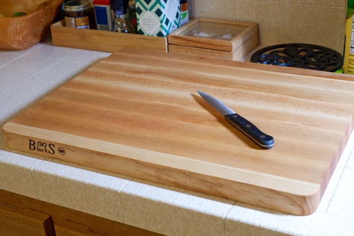 A knife placed on the John Boos Chop-N-Slice Maple Wood Reversible Cutting Board