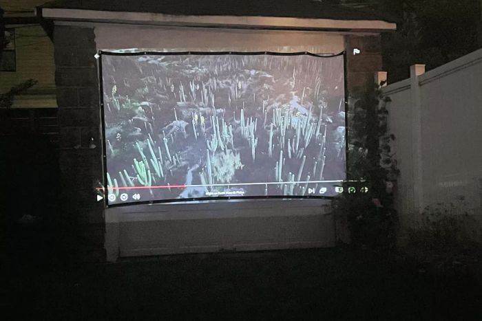 Mdbebbron 120-Inch Projection Screen showcasing a movie under the night sky