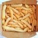 A brown takeout box filled with crispy French fries.