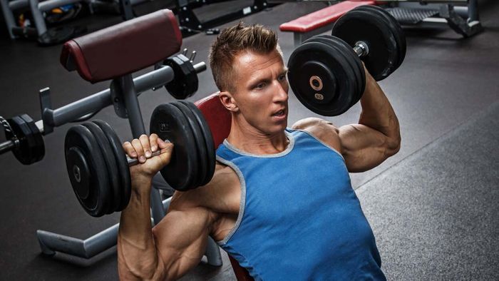 man performing seated dumbbell shoulder press