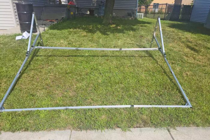 The frame of an Elite Screens Yard Master 2 Outdoor Projection Screen set up on grass