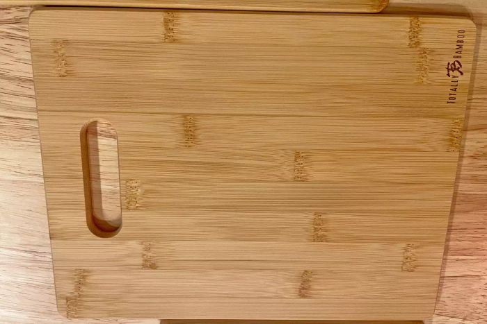 The Totally Bamboo 3-Piece Bamboo Cutting Board Set displayed on a wooden table