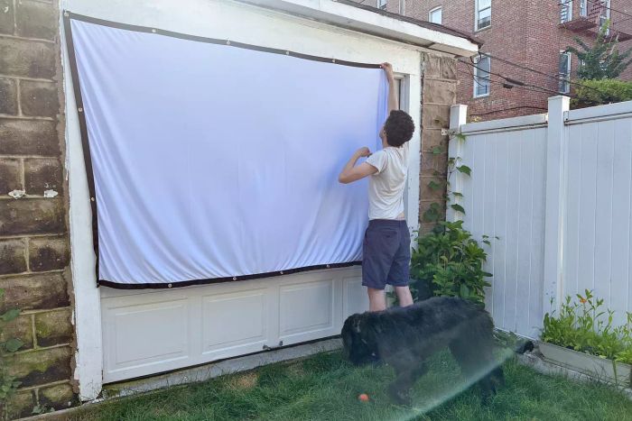 Person setting up a Mdbebbron 120-Inch Projection Screen
