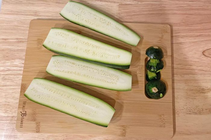 Zucchinis are halved on the Totally Bamboo 3-Piece Bamboo Cutting Board Set