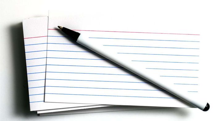 A collection of ruled index cards and a writing tool