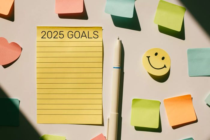 A visual of '2025 Goals' written on a yellow sheet of paper, surrounded by colorful sticky notes