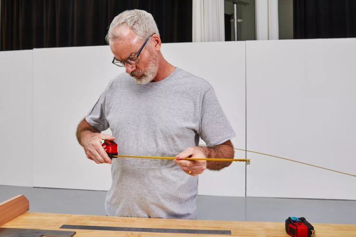 A person reading measurements on the Milwaukee Compact Auto-Lock Tape Measure