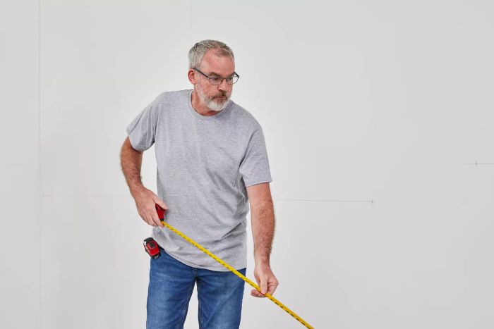 A person extending the Milwaukee Compact Tape Measure