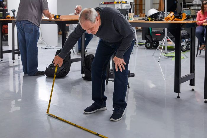 A person measuring the floor with the Crescent Lufkin Shockforce Dual-Sided Tape Measure