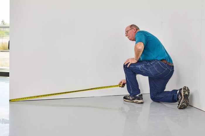 Individual using the Stanley FatMax Tape Measure to measure a wall