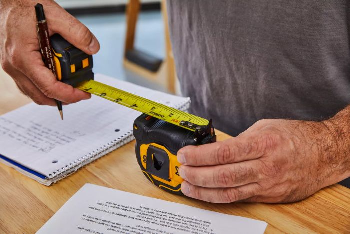 The DeWalt Tough Series Tape Measure is being measured against another tape measure