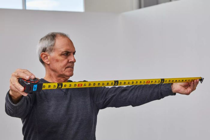 A person examining the Crescent Lufkin Shockforce Dual-Sided Tape Measure