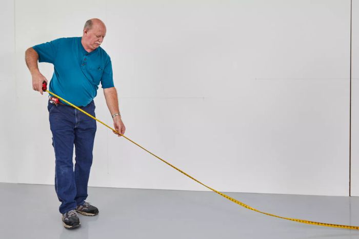 A person taking measurements with the Milwaukee Compact Tape Measure