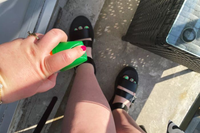 A woman applying OFF! Deep Woods Insect Repellent VIII - Dry (25% DEET) to her legs