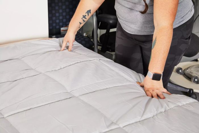 A person touching the surface of the Bedsure All-Season Quilted Down Alternative Comforter