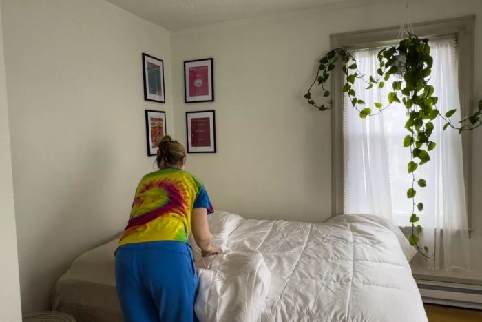 A person neatly arranging the Sijo Clima Tech TempTune Comforter on a bed