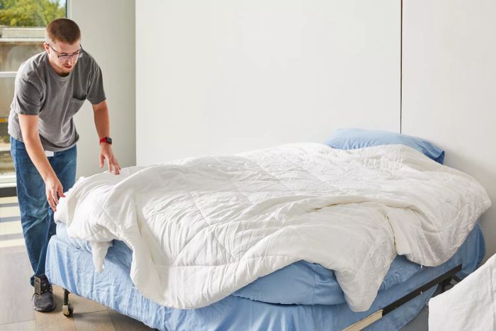 A person neatly arranging the Cozy Earth Bamboo Comforter on a bed