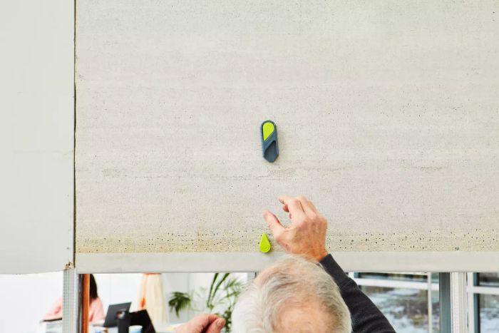 A person operating the Calculated Industries 7310 StudMark Magnetic Stud Finder on a wall