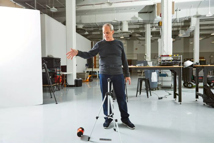 A person accidentally dropping the Johnson Level & Tool 40-0921 Self-Leveling Cross-Line Laser Level Kit on the floor during testing