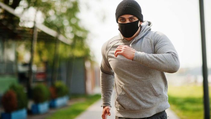Man jogging while wearing a sleek black workout mask