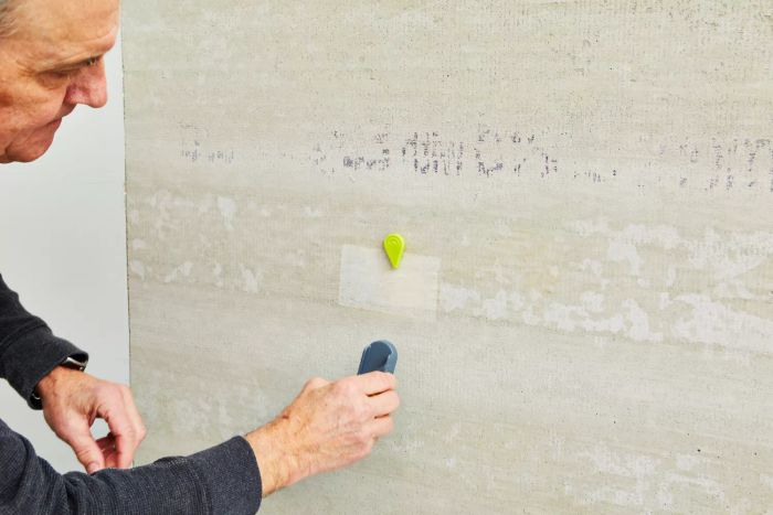 A person operating the Calculated Industries 7310 StudMark Magnetic Stud Finder on a wall