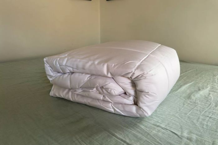 The Sijo Clima Tech TempTune Comforter neatly folded on a bed