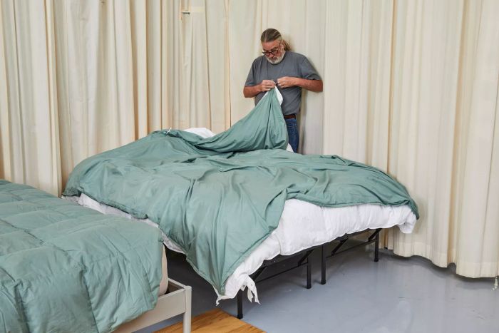 A person holding one corner of the Pottery Barn Hydrocool Moisture Wicking Down Alternative Duvet Insert