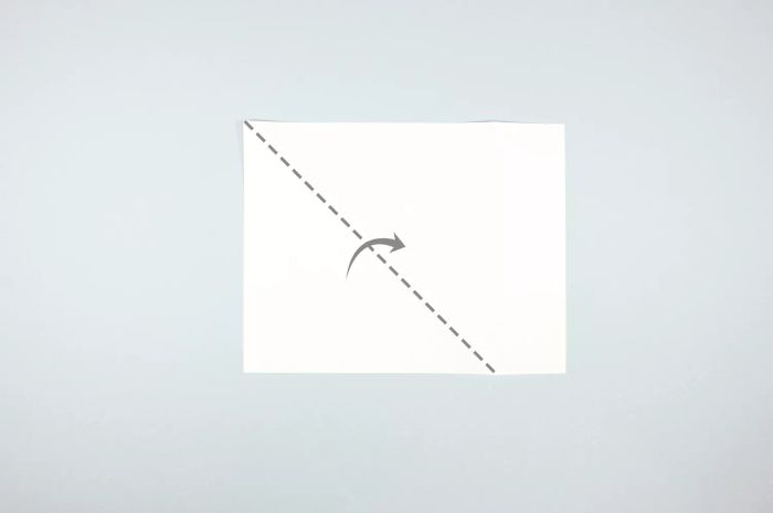 Illustration showing the process of folding a sheet of paper diagonally to form a triangle