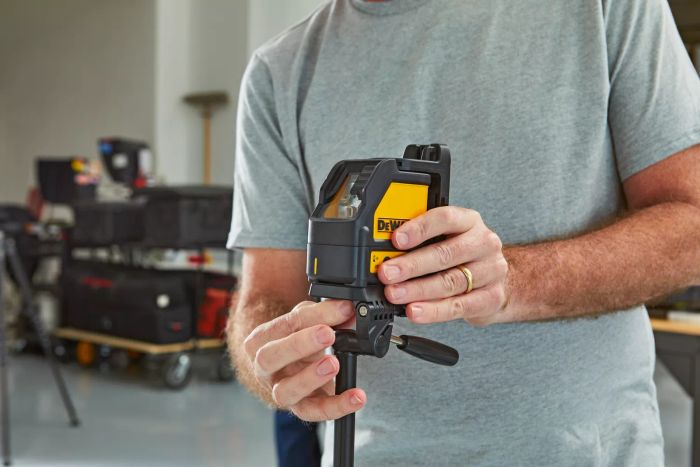 Person adjusting the DEWALT DW088K Cross-Line Laser Level