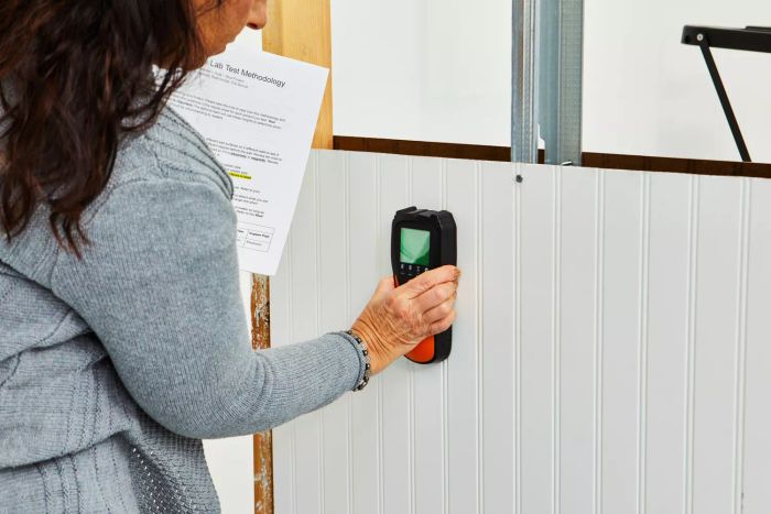 A person using the Mecurate Stud Finder Wall Scanner against a wall
