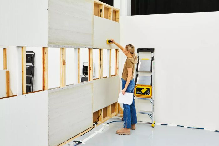 A person using the Franklin Sensors ProSensor 710 Professional Stud Finder against a wall