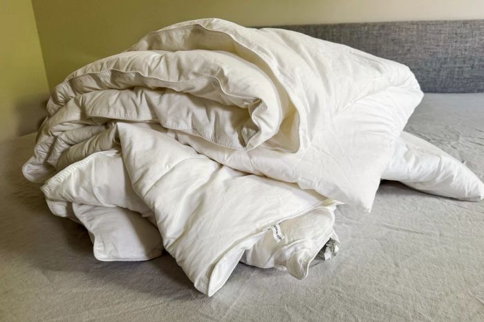 The Saatva Lightweight Down Alternative Comforter folded neatly on a bed