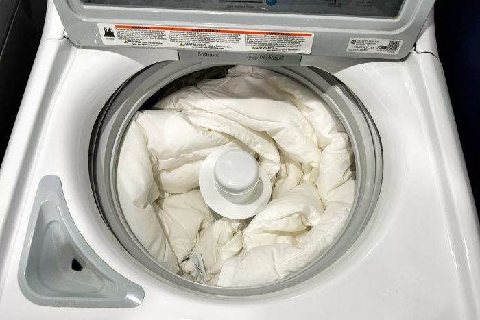 The Saatva Lightweight Down Alternative Comforter inside a washing machine during cleaning