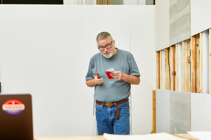 A person holding the Craftsman 3/4-Inch Depth Stud Finder along with its instruction manual