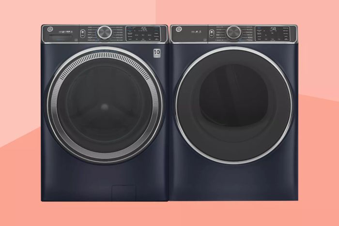 A sleek dark washer and dryer duo set against a peach-colored two-tone backdrop