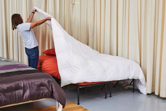 A person lifting the Boll & Branch Down Alternative Duvet Insert