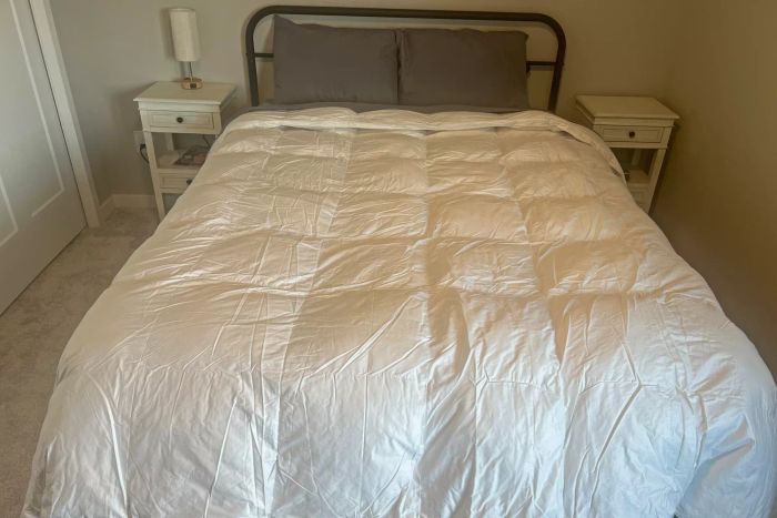 The Crane & Canopy Ultimate Luxe Down Alternative Comforter laid out on a bed in a bedroom