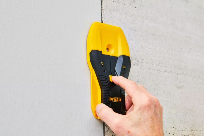 A person operating the Dewalt 1-1/2 in. Stud Finder on a wall