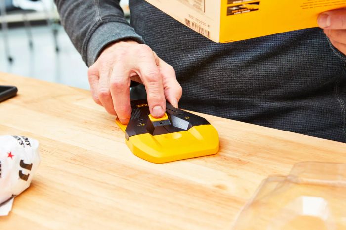 A person testing the Dewalt 1-1/2 in. Stud Finder on a table