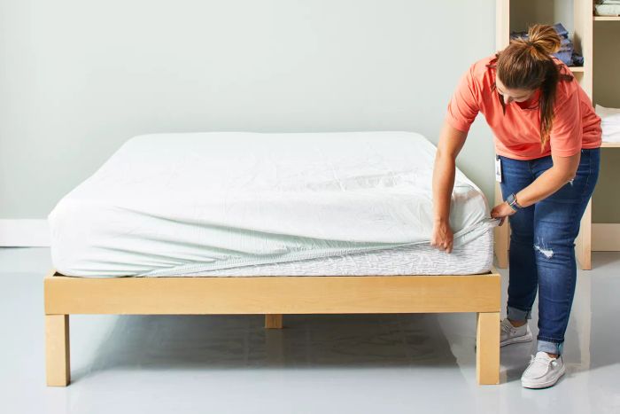 A person tucking the Sweave Bedding Eucalyptus Tencel Lyocell Sheets onto a mattress