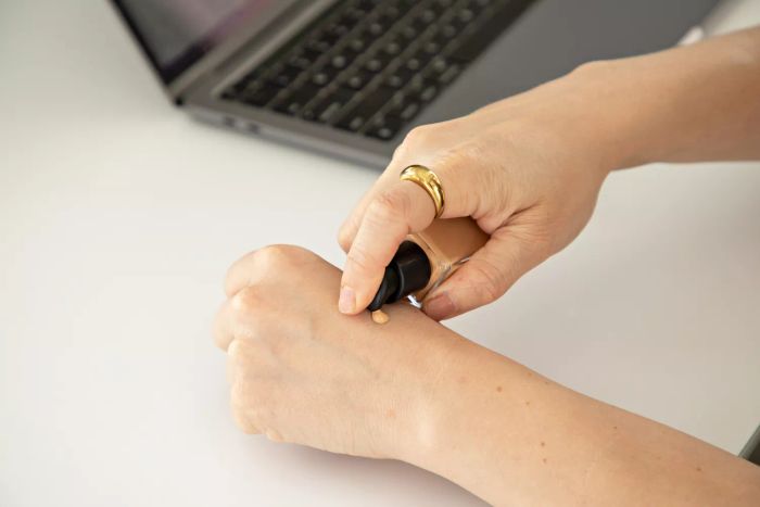 A woman swatching foundation on her hand