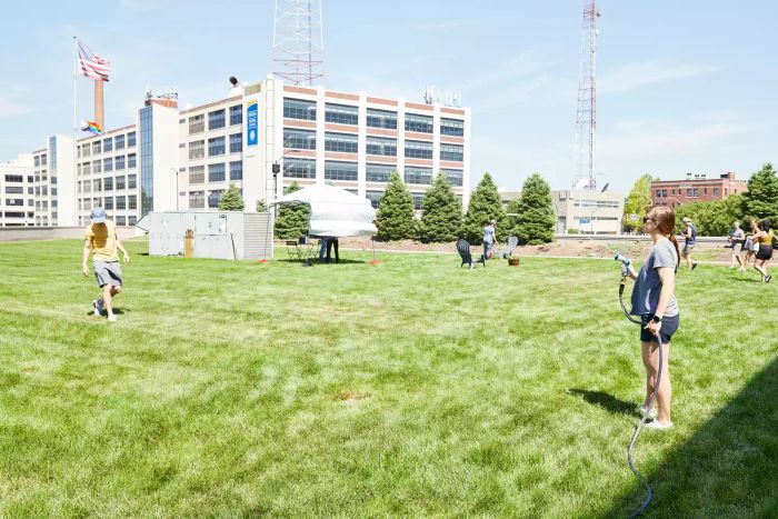 Person spraying water with the INNAV8 Water Hose Nozzle Sprayer across a grass lawn