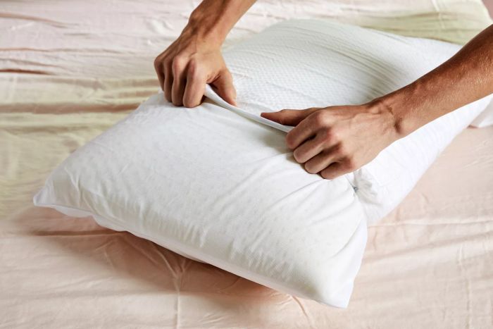Hands pulling the removable cover off the Beautyrest Latex Foam Bed Pillow