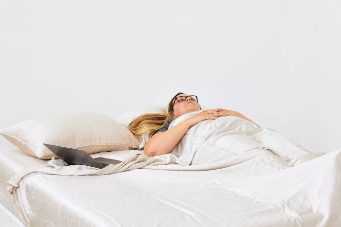 A woman sleeping under a Sheex Arctic Aire Max sheet