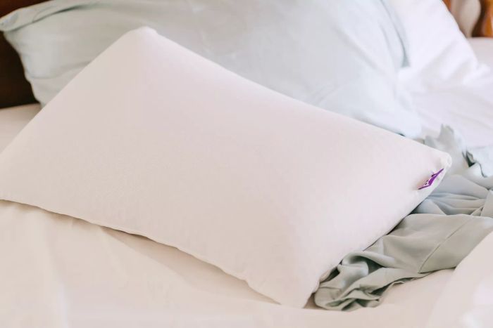 Purple Harmony Pillow showcased on a bed