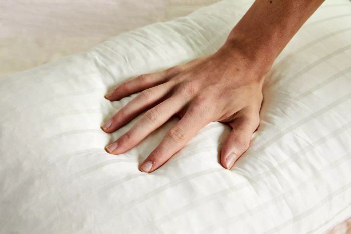 A person applies pressure to the Plush Beds Shredded Latex Pillow