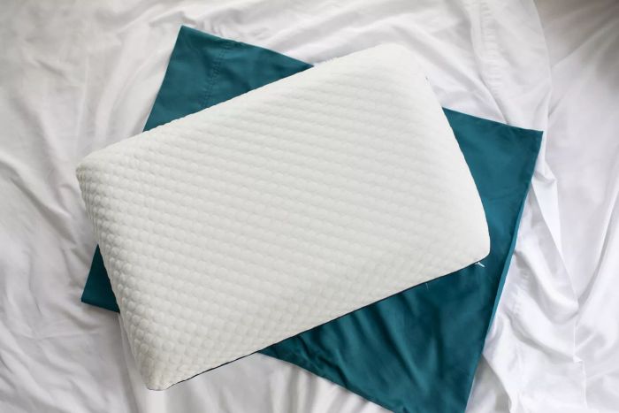 Aerial view of the WEEKENDER Ventilated Gel Memory Foam Pillow resting on a bed, complete with a pillowcase